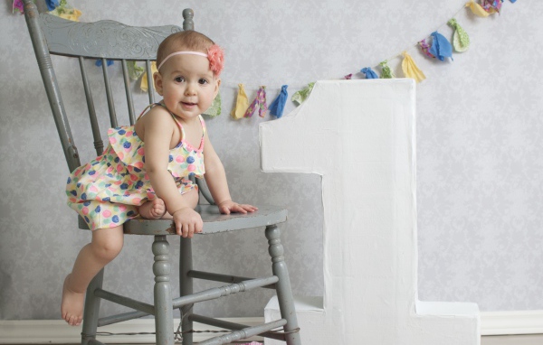 Маленькая девочка в платье на стуле