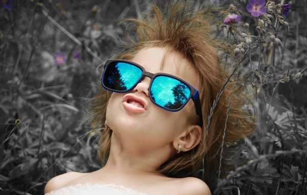 Маленькая девочка в очках со смешной прической