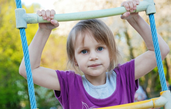 Маленькая девочка на подвесной лестнице 