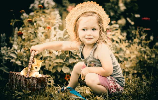 Маленькая девочка с корзиной с рыжим котенком