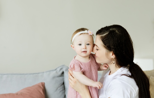 Маленькая девочка с мамой на сером фоне