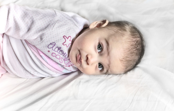 Маленький новорожденный ребенок лежит на кровати 