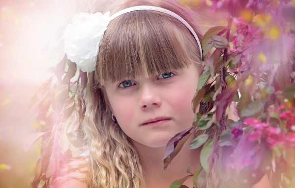 Грустная маленькая девочка у ветки дерева 