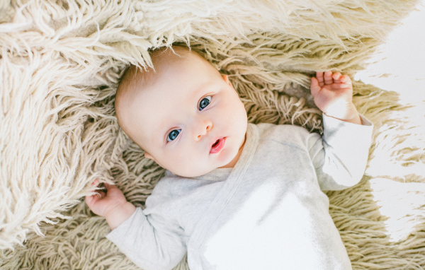 Маленький грудной ребенок на меховом покрывале 