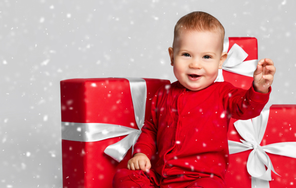 Улыбающийся ребенок с большими красными подарками 