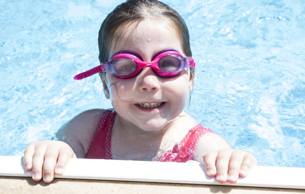 Улыбающаяся девочка в очках в бассейне