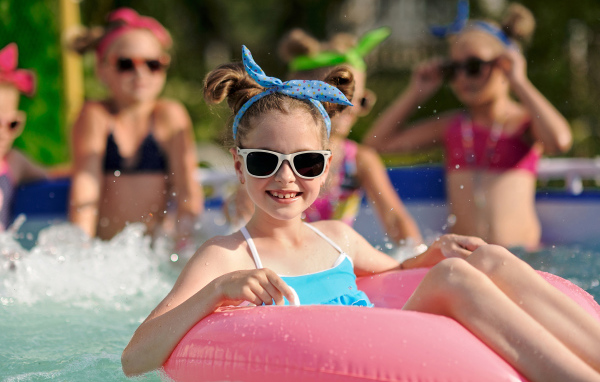 Улыбающаяся девочка со спасательным кругом в бассейне 