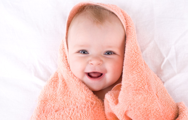 Улыбающийся грудной ребенок в полотенце
