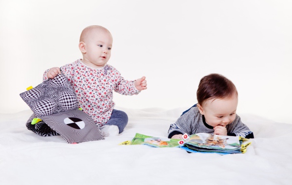 Two little children playing on a white background
