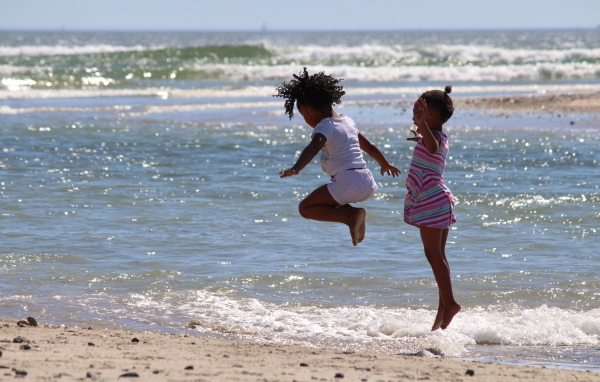 Две маленькие девочки играют на морском берегу