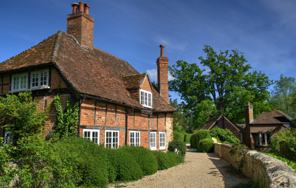 Кирпичный старый дом под голубым небом, Англия 