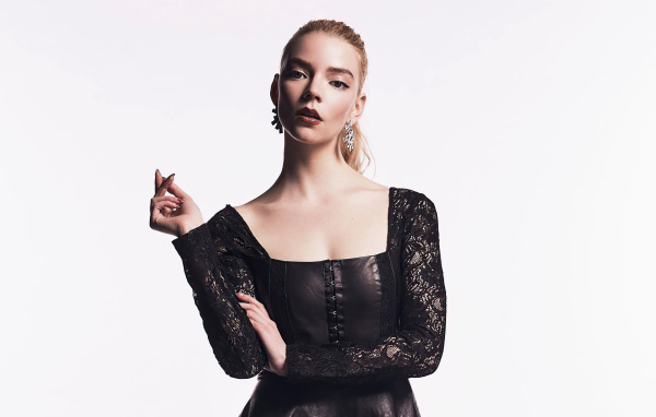 Актриса Аня Тейлор-Джой в черном наряде на белом фоне