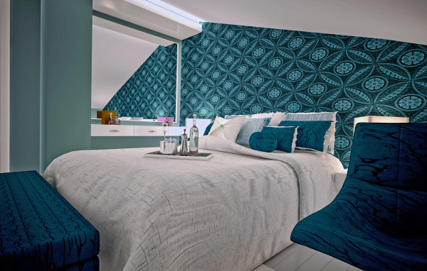 Спальня с большой серой кроватью и красивыми стенами