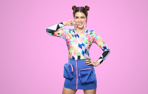 Яркая индийская актриса и модель Крити Санон на розовом фоне