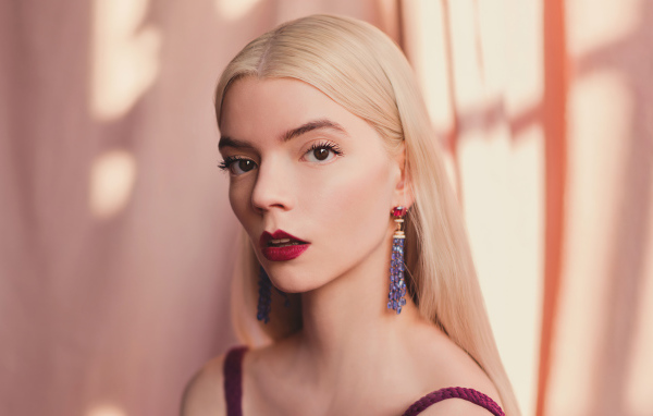 Милая блондинка, актриса Аня Тейлор-Джой на розовом фоне