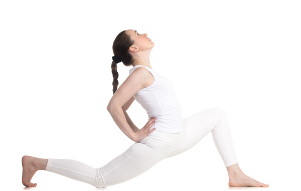 Девушка в белом костюме делает растяжку