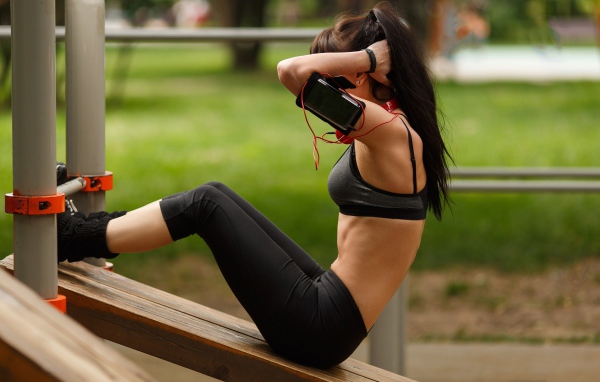 Девушка качает пресс на тренажере 