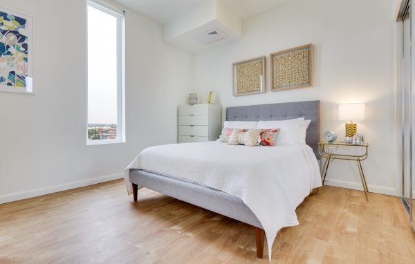 Высокое окно в спальне с большой кроватью 