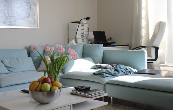 Большой серый диван в гостиной со столом 