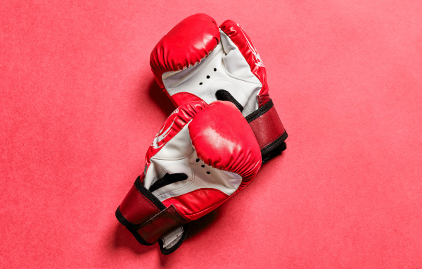 Красные боксерские перчатки на розовом фоне 