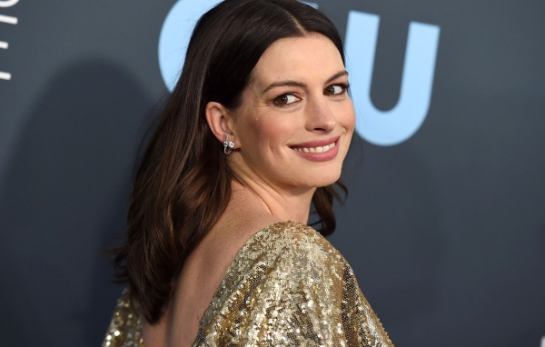 Улыбающаяся актриса Энн Хэтэуэй в ярком платье