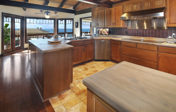 Деревянная мебель на кухне с окнами с видом на море