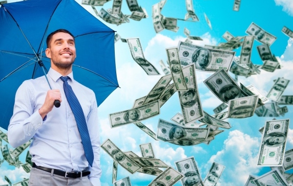 Мужчина  с голубым зонтом под денежным дождем