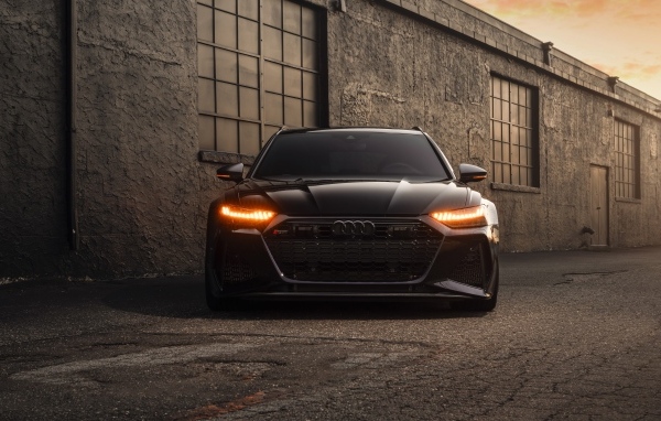 Черный автомобиль Audi RS7 у стены