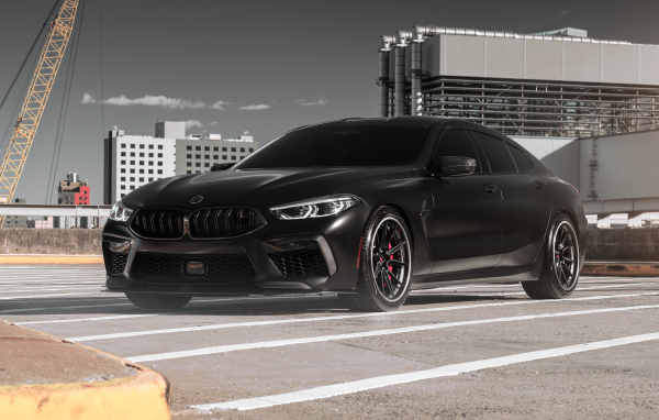 Черный автомобиль BMW M8 на стройке
