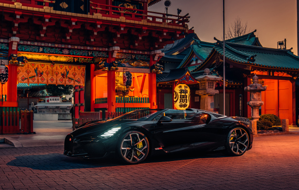 Черный спортивный автомобиль Bugatti W16 Mistral  у здания