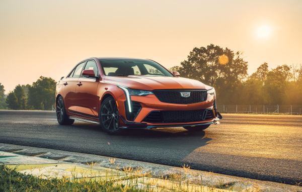 Красный Cadillac CT4-V на дороге на фоне солнца 