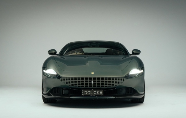 Автомобиль Ferrari Roma на сером фоне вид спереди