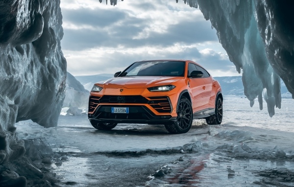 Оранжевый внедорожник Lamborghini Urus у ледяной пещеры