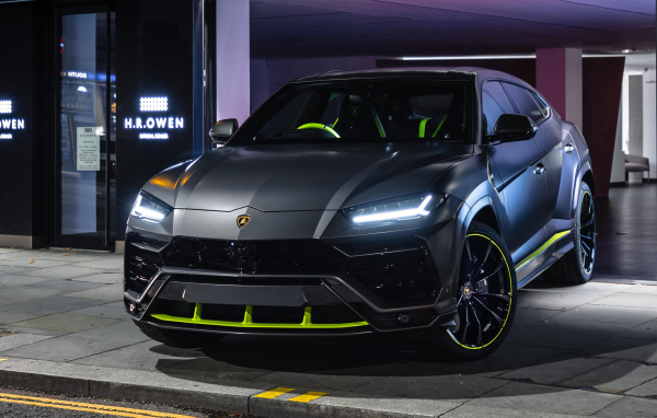 Серебристый Lamborghini Urus с включенными фарами