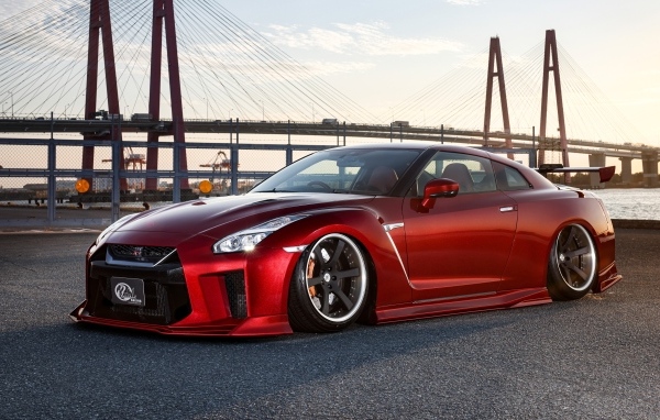 Красный автомобиль Nissan GTR 35R на фоне моста