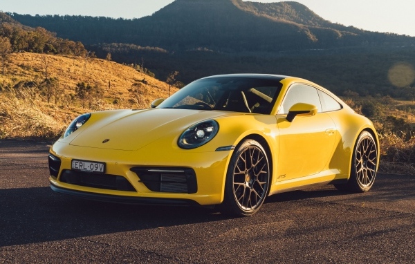 Желтый быстрый автомобиль Porsche 911 Carrera GTS вид спереди