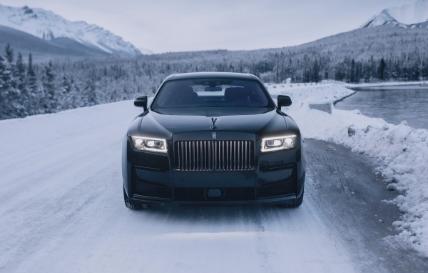 Черный автомобиль Rolls-Royce Black Badge Ghost  на зимней дороге