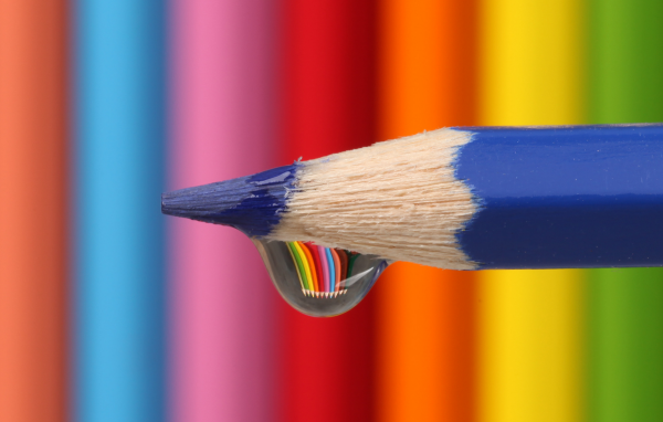 Капля воды стекает с синего карандаша