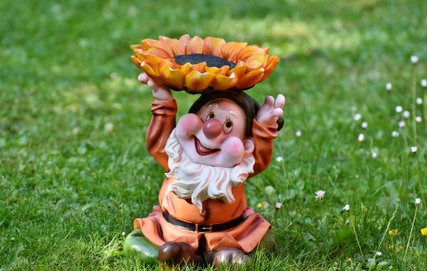 Садовая фигура гном за зеленой траве