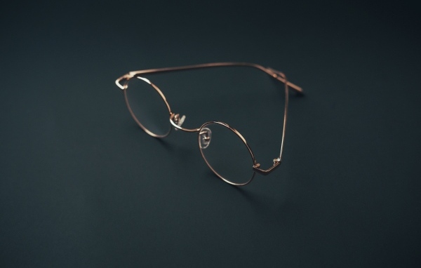 Очки лежат на серой поверхности