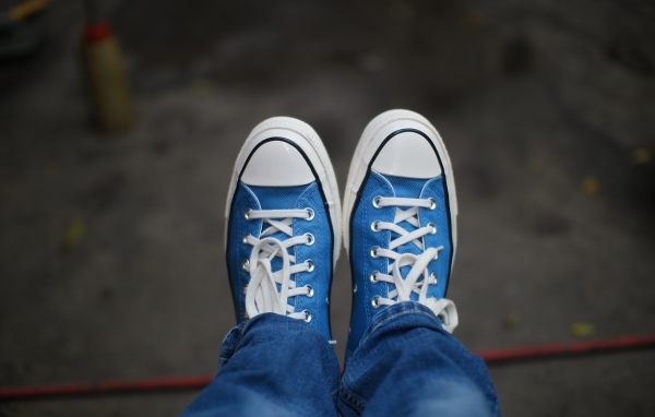 Кеды на ногах в джинсах