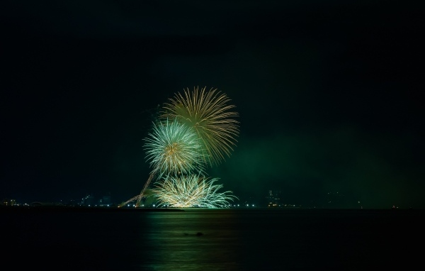 Вид с воды на красивые искры салюта
