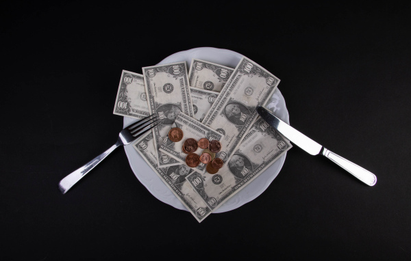 Тарелка с долларами на черном фоне