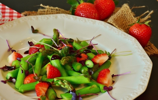 Спаржа в тарелке с клубникой