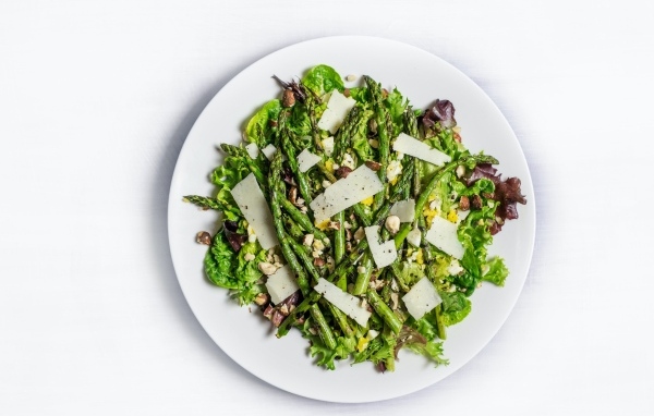 Спаржа на белой тарелке с сыром