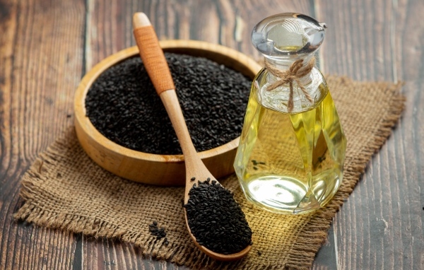 Черные семена на столе с маслом
