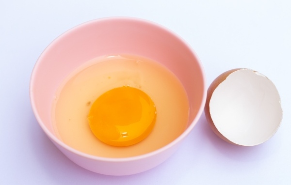 Разбитое яйцо на столе со скорлупой