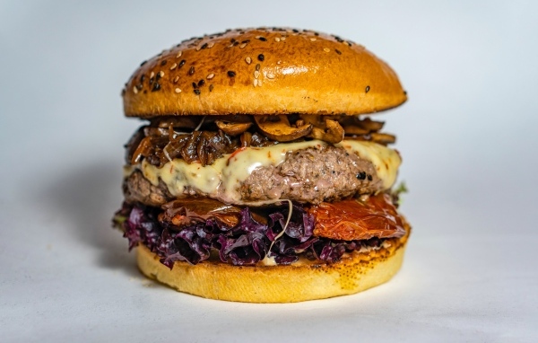 Ароматный сочный гамбургер на сером фоне крупным планом