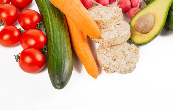 Свежие аппетитные овощи и хлопья на белом фоне