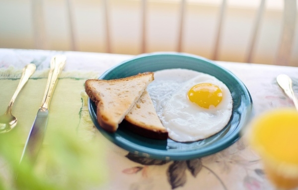 Яичница с хлебом на столе на завтрак 